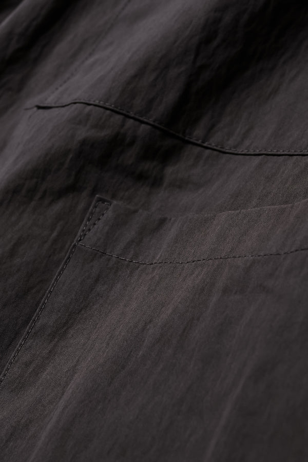 Close up fabric shot of the Premise Cargo in Jet Black, a relaxed-fit pant with adjustable waistband, clean front pleats, and straight-leg silhouette.