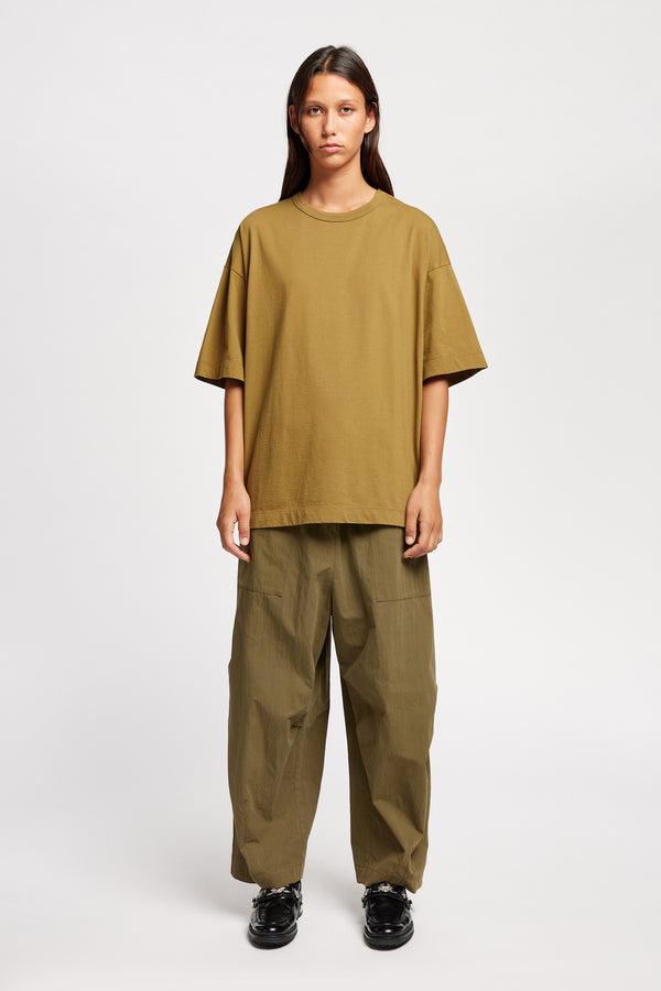 Front of Model wearing the Premise Cargo in Kelp Green, a relaxed-fit pant with adjustable waistband, clean front pleats, and straight-leg silhouette.