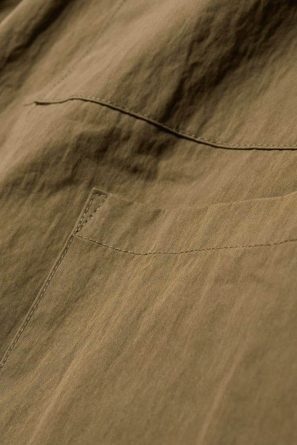 Close up fabric shot of the Premise Cargo in Kelp Green, a relaxed-fit pant with adjustable waistband, clean front pleats, and straight-leg silhouette.