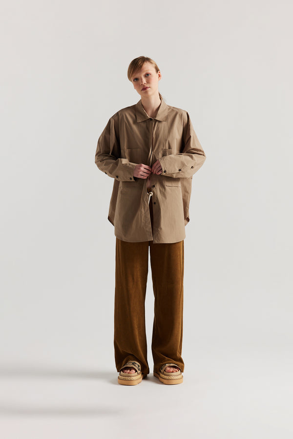 Front view of slouchy track pants in coffee brown cotton terry with straight-leg fit and cord-tie waistband.
