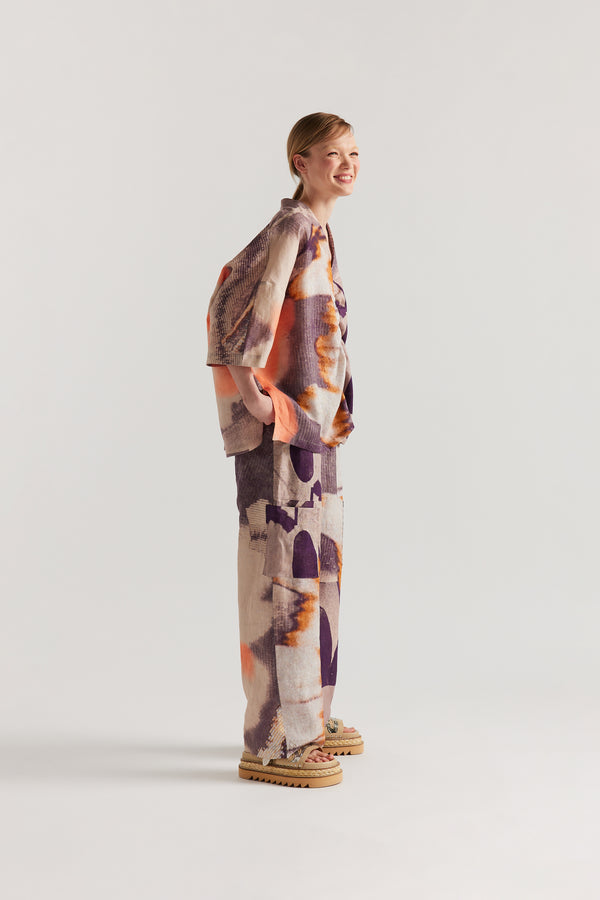 Side view of Model wearing the Psyche Top, a  relaxed linen V-neck top in the Kloke developed Chaos print with gathered centre-front detail.