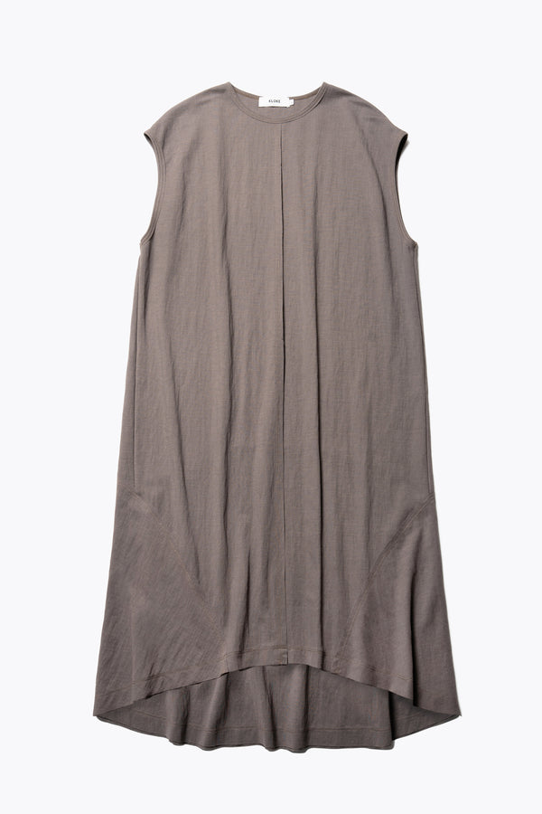 Flat Front of the Recess dress in taupe, a sleeveless crew-neck midi dress with exposed seams, raw-edge finish, and a relaxed silhouette that falls just below the knees, offering a versatile look for casual or elevated occasions.