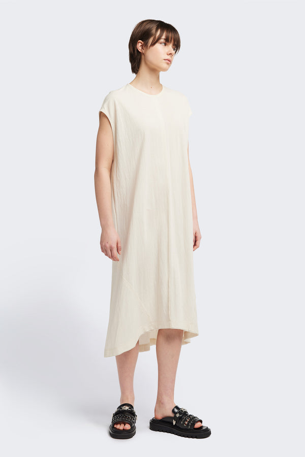 Front of the Recess dress in ecru, a sleeveless crew-neck midi dress with exposed seams, raw-edge finish, and a relaxed silhouette that falls just below the knees, offering a versatile look for casual or elevated occasions.