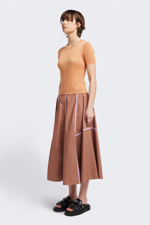 front of the brown/lilac Regarder Bound Skirt in a lightweight cotton fabric, featuring a fuller silhouette with contrast bound seam details, midi length, and a back invisible zip closure.