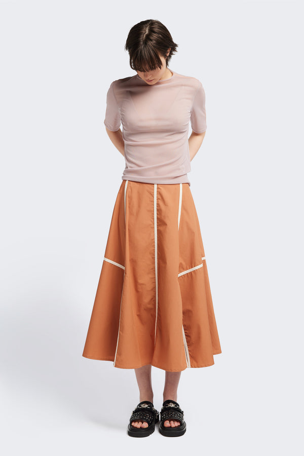 front of the burnt orange/Ecru Regarder Bound Skirt in a lightweight cotton fabric, featuring a fuller silhouette with contrast bound seam details, midi length, and a back invisible zip closure.