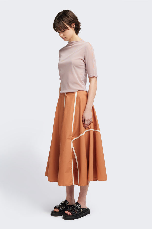 front of the burnt orange/Ecru Regarder Bound Skirt in a lightweight cotton fabric, featuring a fuller silhouette with contrast bound seam details, midi length, and a back invisible zip closure.