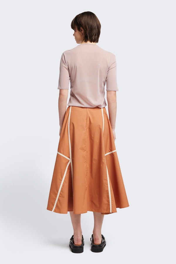 Back of the burnt orange/Ecru Regarder Bound Skirt in a lightweight cotton fabric, featuring a fuller silhouette with contrast bound seam details, midi length, and a back invisible zip closure.