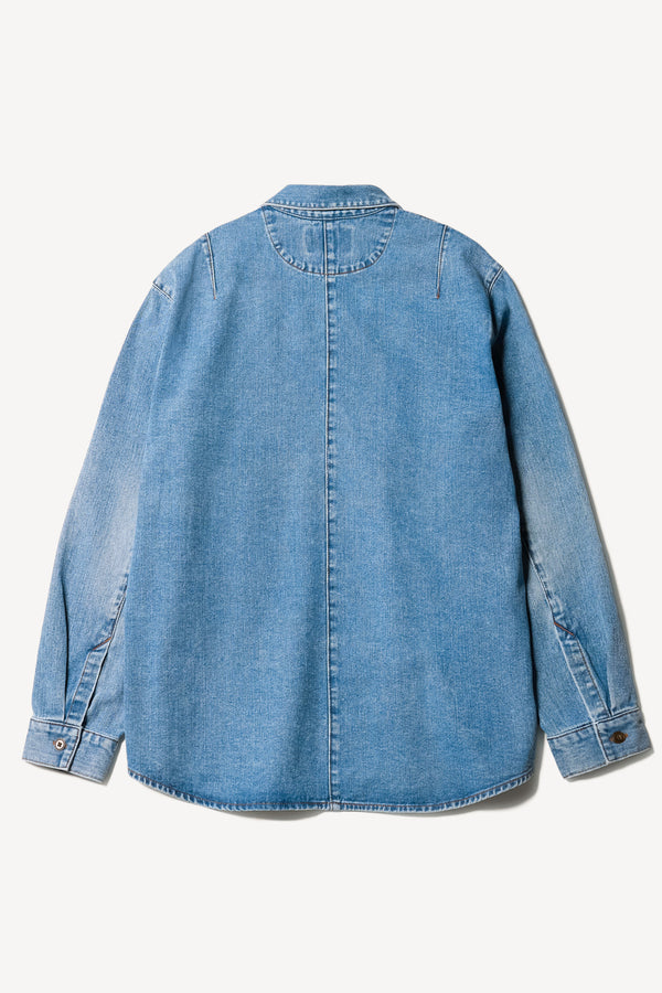 Flat back of the Region oversized denim shirt in mid-blue, featuring utility chest pockets.