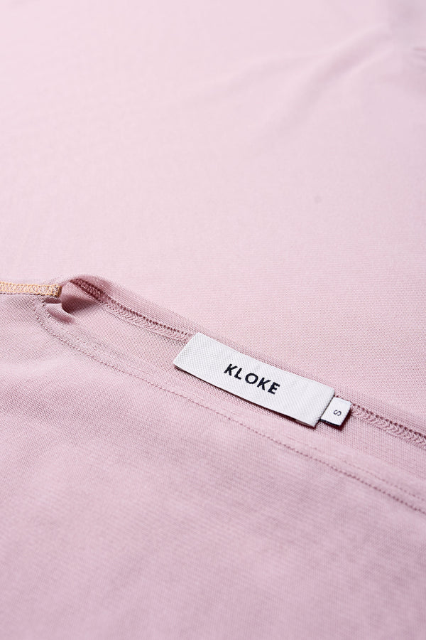 Close up details of the Rein Mesh Long Sleeve Top in Pale Mauve and Peach. Featuring a high neckline, contrast flatlock seams, and sheer, lightweight fabric, perfect for layering. 