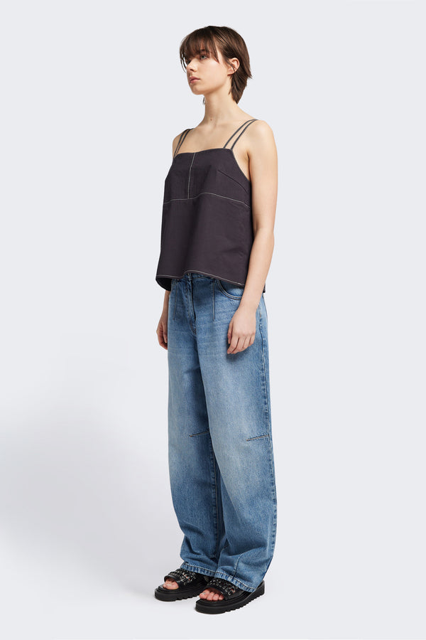 Front angle view of model in the the Reset Jean, a darted relaxed baggy jean - in mid blue fade