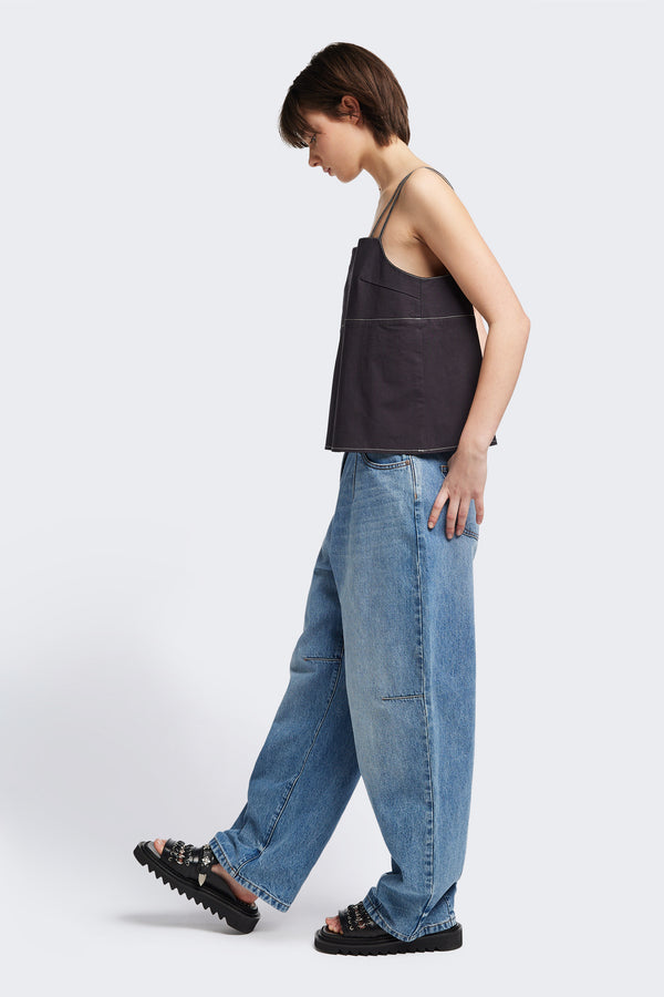 Side view of model in the the Reset Jean, a darted relaxed baggy jean - in mid blue fade