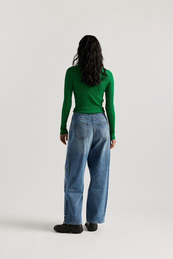 Back view of model in the the Reset Jean, a darted relaxed baggy jean - in mid blue fade