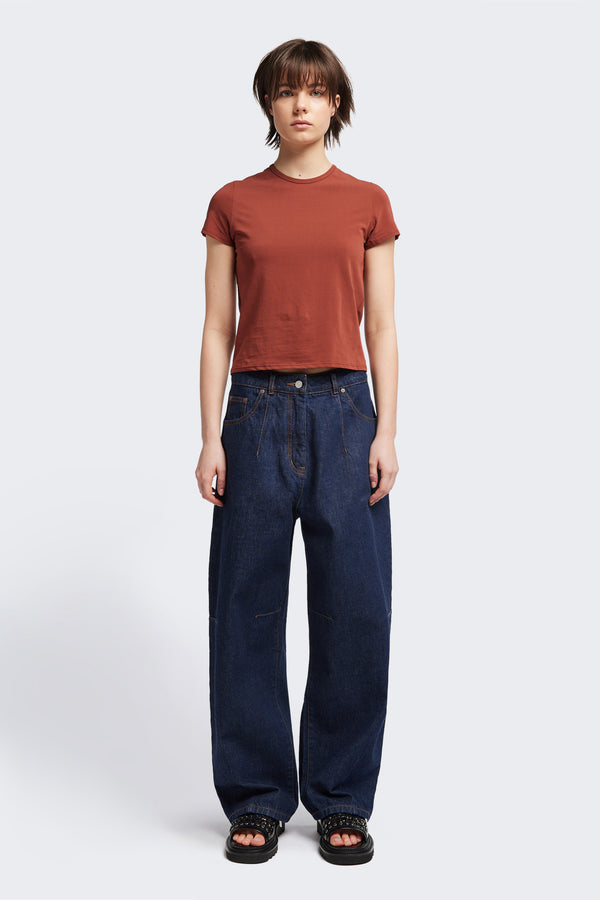 Font view of the model in The Reset Jean Indigo is a relaxed baggy jean featuring two darts at the centre front waistline and darts across the knee.  