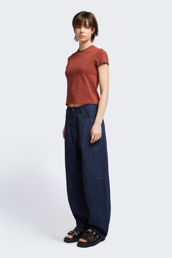 Font angle view of the model in The Reset Jean Indigo is a relaxed baggy jean featuring two darts at the centre front waistline and darts across the knee.  