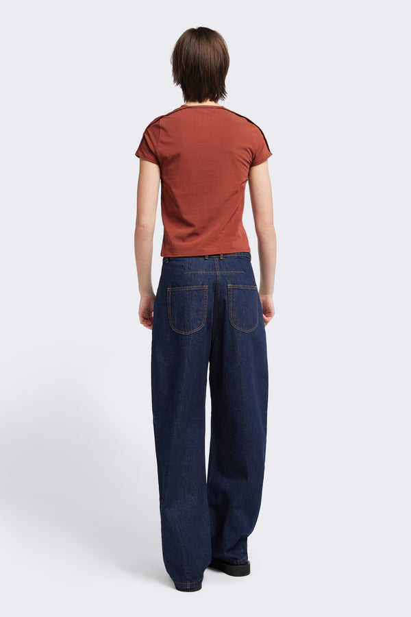 Back view of the model in The Reset Jean Indigo is a relaxed baggy jean featuring two darts at the centre front waistline and darts across the knee.  
