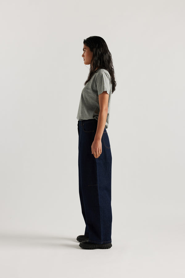 The Oceania Tee side profile view on female model, a fitted style t-shirt cut from premium organic cotton jersey in Heather Grey. Available in five sizes.   