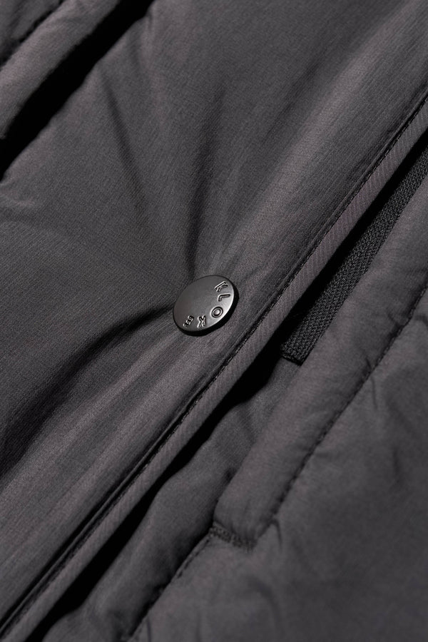 Close-up detail shot of zip and stud button closure on the Restore Coat

