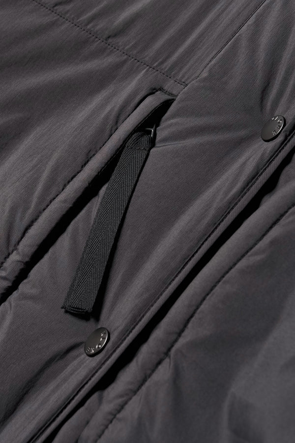 Close-up of zip and stud button closure on the Restore Coat in Black
