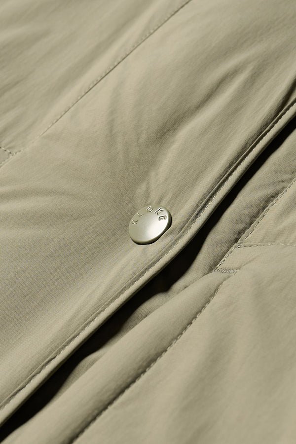 Close-up detail shot of zip and stud button closure on the Restore Coat in dusty olive green 