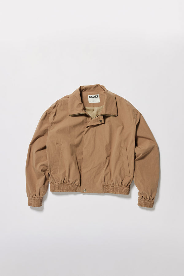 Flat Front of the fawn brown Reverie Jacket showing two-way zip closure and topstitched welt pockets.