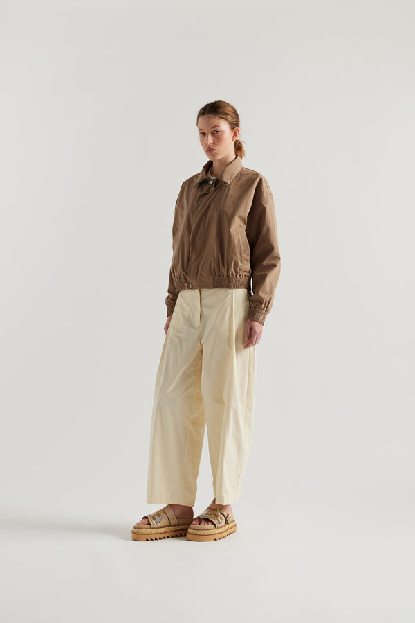 front view of model in the fawn brown Reverie Jacket showing two-way zip closure and topstitched welt pockets.