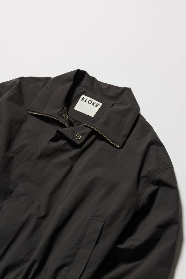 Close up details shot of slate Reverie Jacket showing Collar, two-way zip closure and topstitched welt pockets.