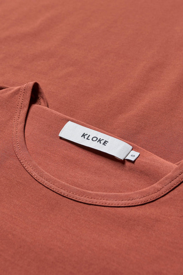 Close up fabric details of the Ride Short Sleeve top in Brick. A crew neck jersey top in Japanese cotton stretch with cap sleeves.