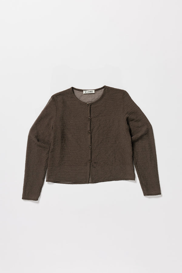 Flat Front of the Rising LS Shirt in Brown. A slim-fitting long sleeve shirt with rounded self-bind collar and straight hem.