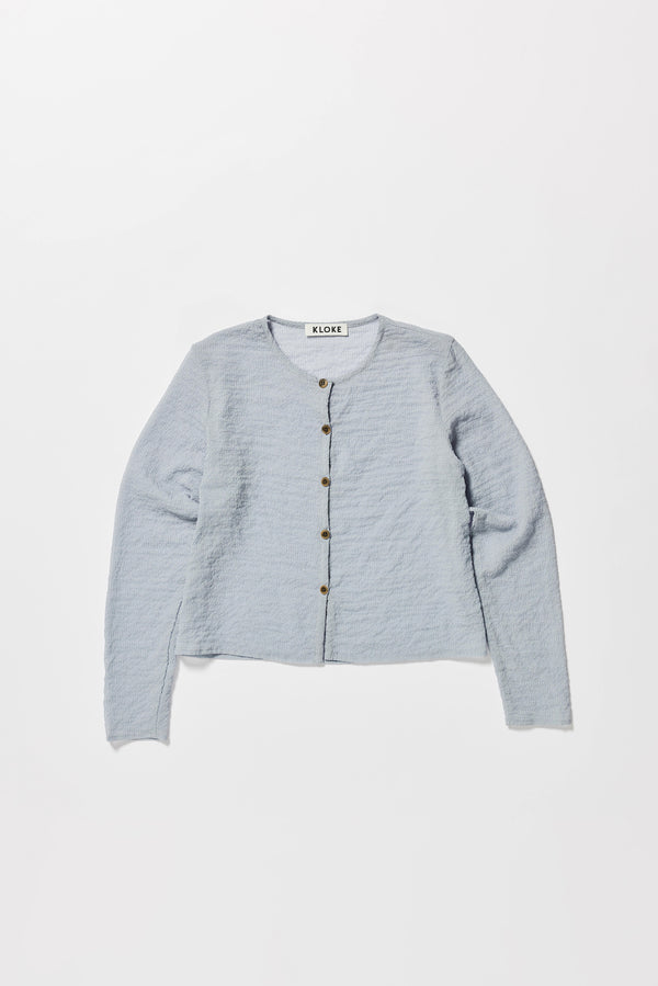 Flat Front of the Rising LS Shirt in Pale Blue. A slim-fitting long sleeve shirt with rounded self-bind collar and straight hem.