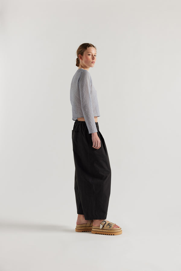 Side View of model in the Rising LS Shirt in Pale Blue. A slim-fitting long sleeve shirt with rounded self-bind collar and straight hem.