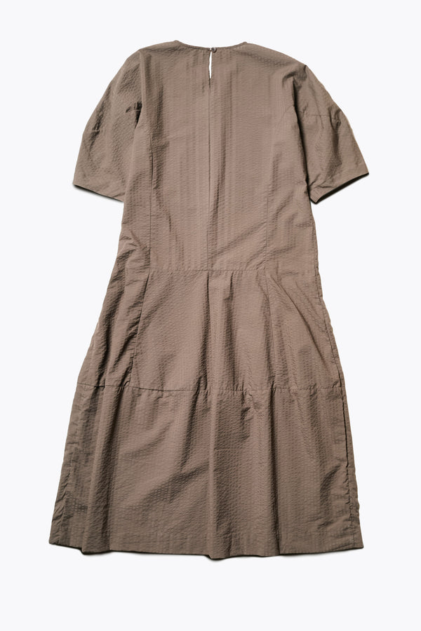 Back of the Scoria Dress, a long-panelled cotton seersucker dress with voluminous sleeves, structured panel details, and a fuller skirt, perfect for an effortless summer look. Available in 5 sizes. 