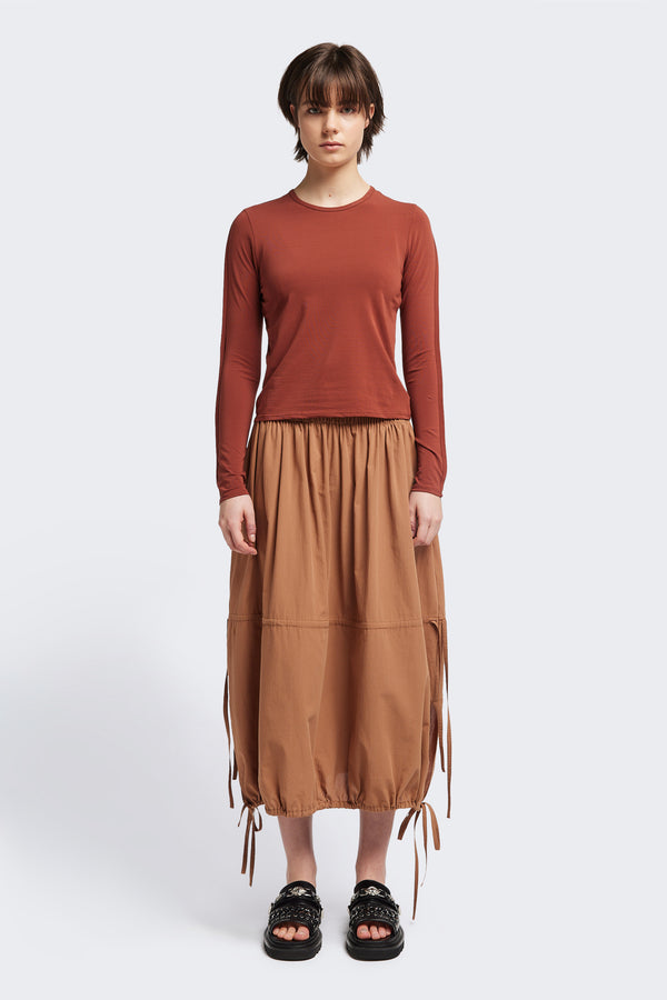 Front view of the Seclude long sleeve top in Brick. A Slim-fit crew neck top in soft cotton stretch, featuring an exposed bound seam curving across the back and sleeves.