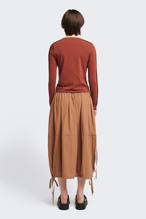 Back view of the Seclude long sleeve top in Brick. A Slim-fit crew neck top in soft cotton stretch, featuring an exposed bound seam curving across the back and sleeves.