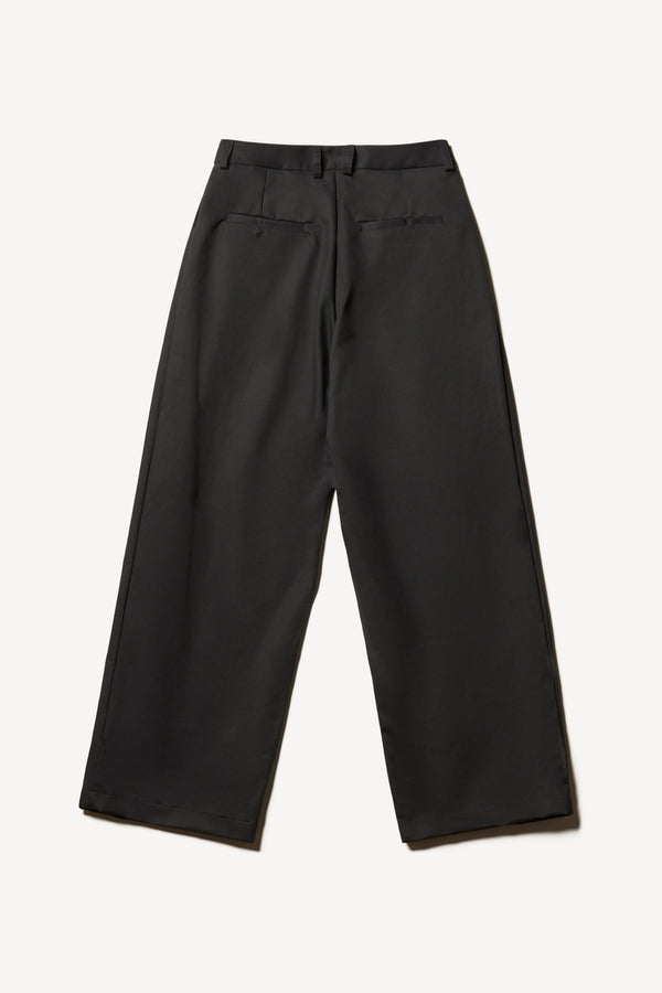 Flat Back of the Seleno pants in black with a relaxed, tapered leg and pleat detailing.