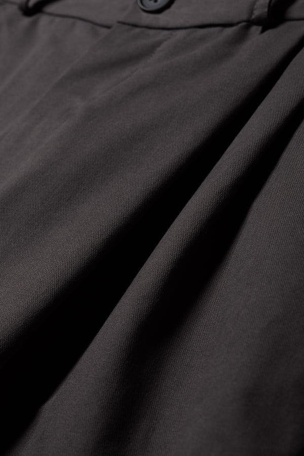 Fabric Detail of the Seleno pants in black with a relaxed, tapered leg and pleat detailing.