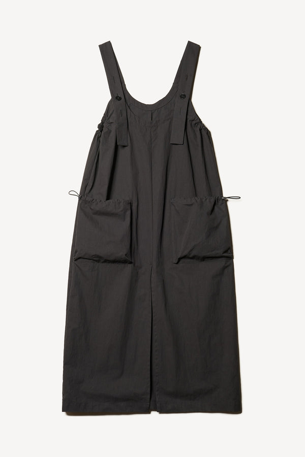 Flat Font of the Shoreline full-length pinafore dress in black with deep round neckline and front patch pockets, a relaxed-fit silhouette. 
