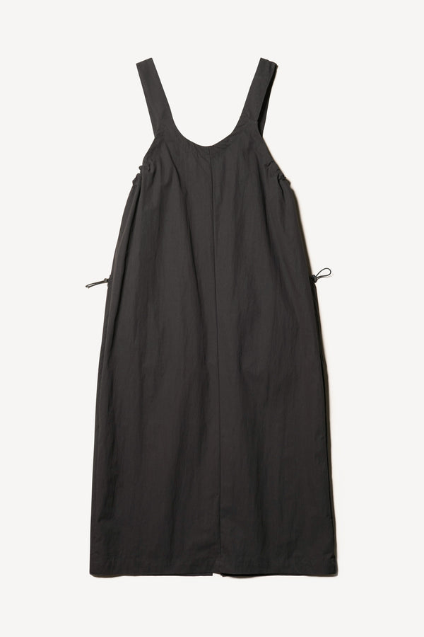 Flat back of the Shoreline full-length pinafore dress in black with deep round neckline and front patch pockets, a relaxed-fit silhouette. 