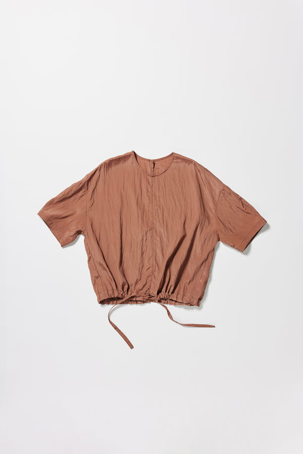 Flat front of the cocoa brown Stillness Top with round neckline and centre front seam detail. Showing cinched at hem with the self tie. 