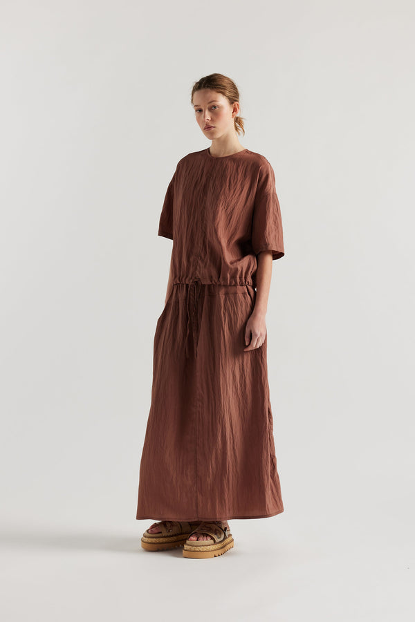 Front of model in the cocoa brown Stillness Top with round neckline and centre front seam detail.