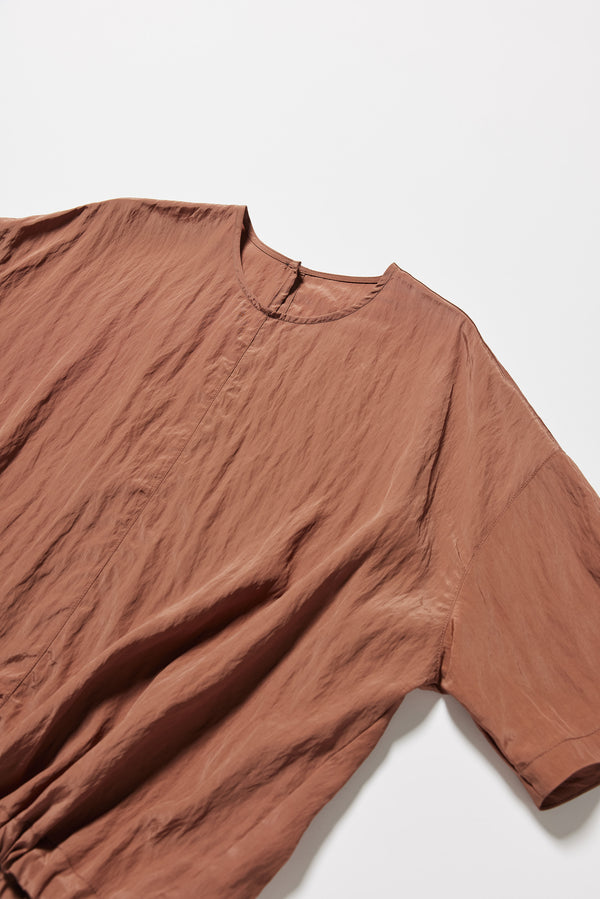 Detail shot of the sand beige Stillness Top showcasing the fabric texture and round neckline