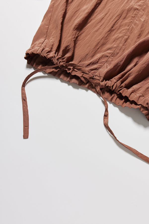 Detail shot of the sand beige Stillness Top showcasing the self-encased hem tie on the Stillness Top.