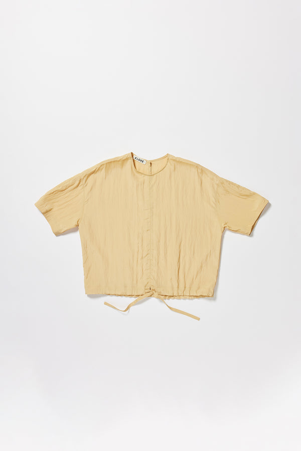 Flat front of the sand beige Stillness Top with round neckline and centre front seam detail.