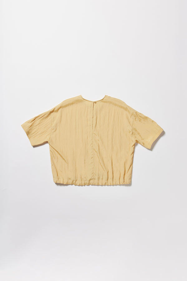 Flat back the sand beige Stillness Top with round neckline and centre front seam detail.