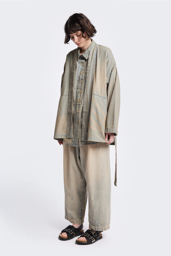 Front of the unisex( women ) Subterra Wide wrap shawl collar jacket with kimono-style sleeves, crafted from cotton denim, featuring front patch pockets and a waist tie to cinch the loose silhouette. Available in 5 sizes.  