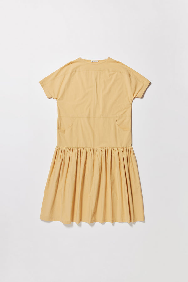 Flat front off the Surrender Dress in sand showing panelled detailing, dropped waist, and gathered skirt. 