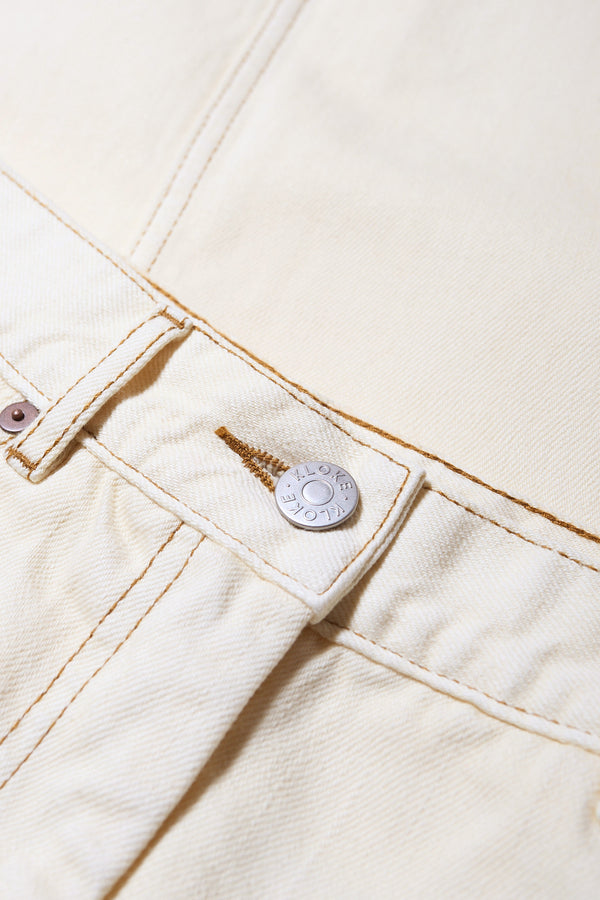 Close up of the Temple Jean in Ecru beige, 100% Cotton. A relaxed laid-back fit, featuring traditional 5 pocket configuration and Kloke hardware. Available in 10 sizes. 