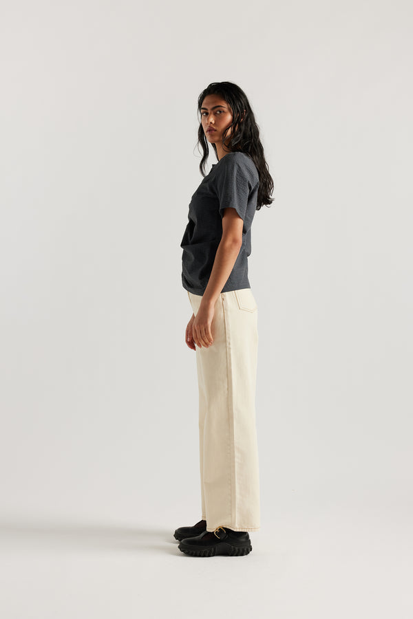 Model wearing relaxed straight-leg ecru jeans in a timeless vintage wash with high to mid rise and slim hip fit