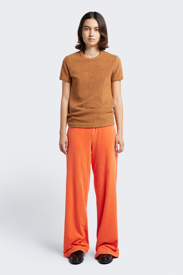 The Prone Towelling Track Pant Tangerine is a slouchy track pant with an elasticated waist band and crafted from Okeo-tex standard cotton terry.