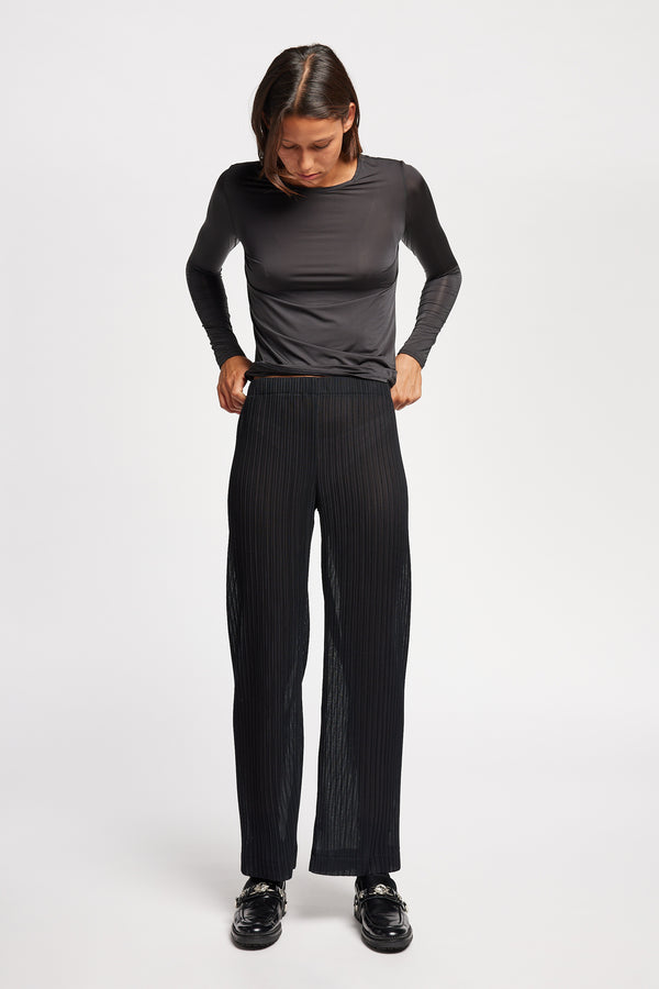 Front of Model in the black Trace Pant crafted from a recycled Japanese polyester with a relaxed straight leg and elastic waistband. 