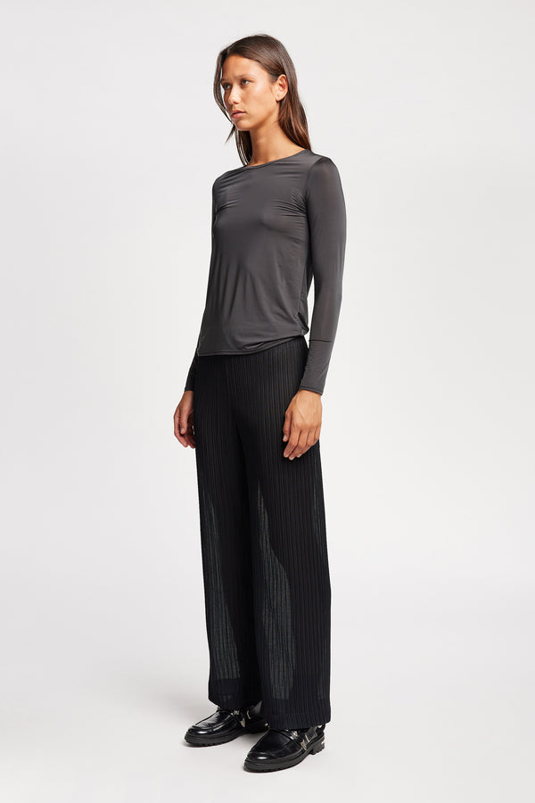 Front of Model in the black Trace Pant crafted from a recycled Japanese polyester with a relaxed straight leg and elastic waistband. 